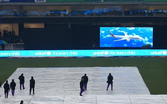 Covers are seen on the pitch as rain delays the start of play