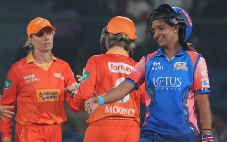 Mumbai Indians captain Harmanpreet Kaur smiling and extending her hand towards Gujarat Giants players after a Women's Premier League (WPL) 2025 match.
